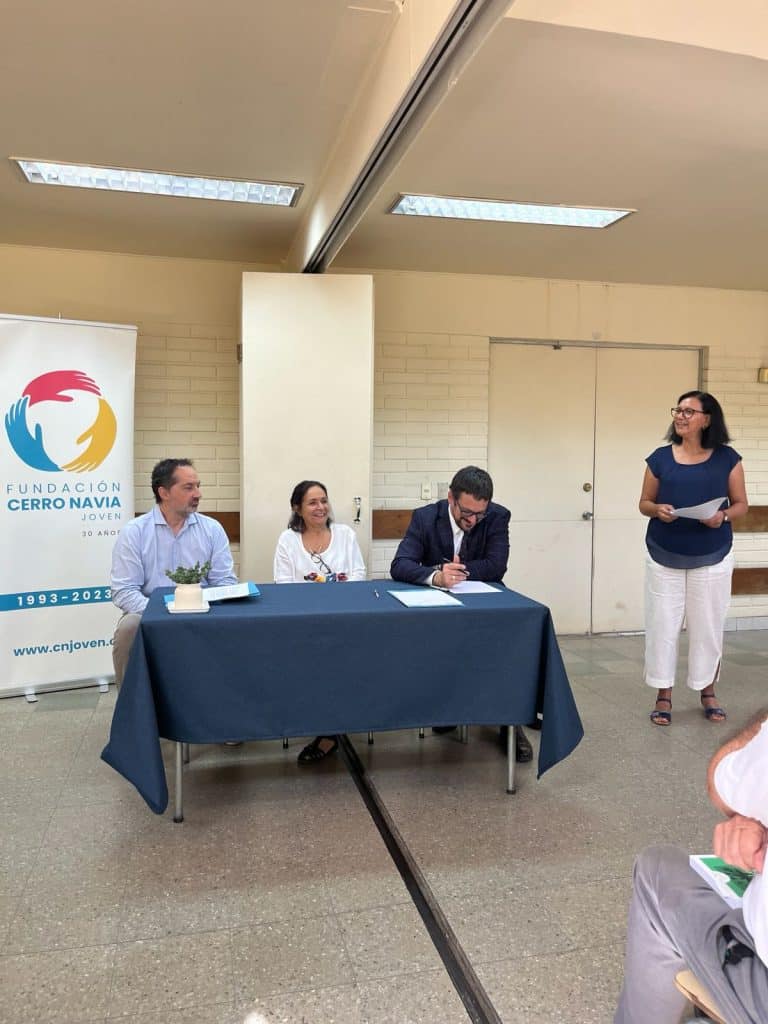 Firma de documentos en la Fundación Cerro Navia Joven por la Nueva alianza con SERNAC.