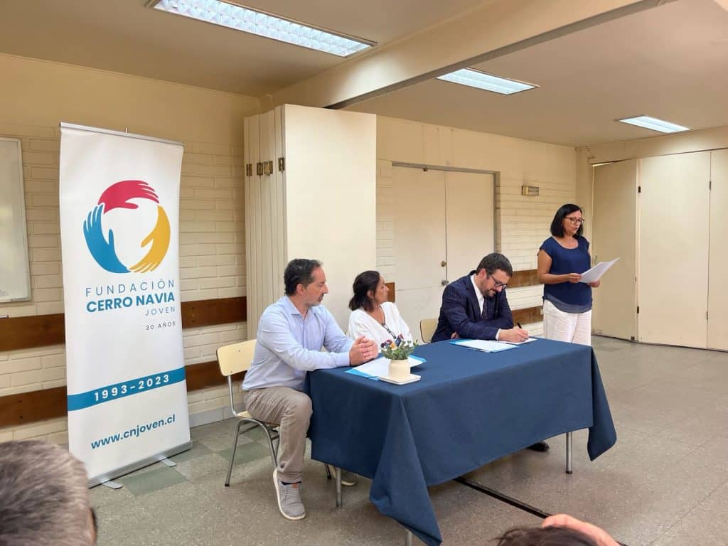 Firma de documentos en la Fundación Cerro Navia Joven por la Nueva alianza con SERNAC.