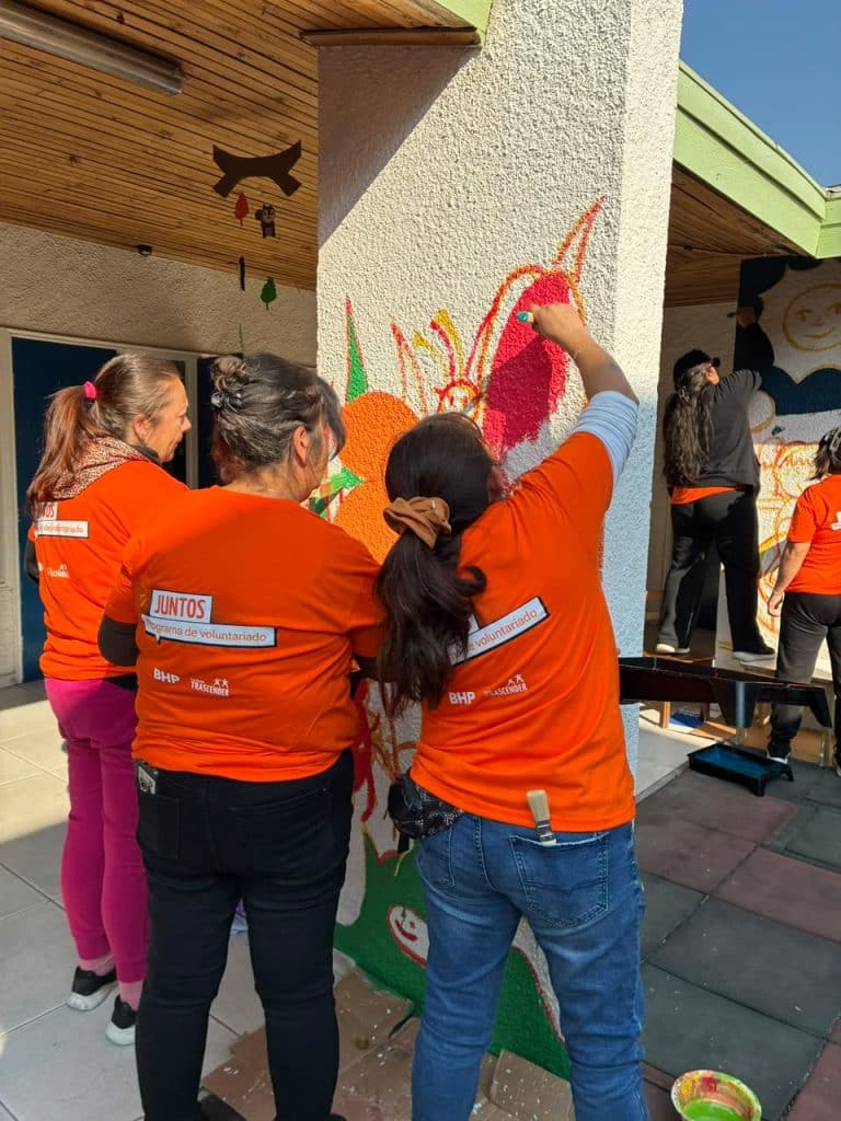 Voluntarios/as pintan muros para mejorar los espacios comunitarios para los niños.