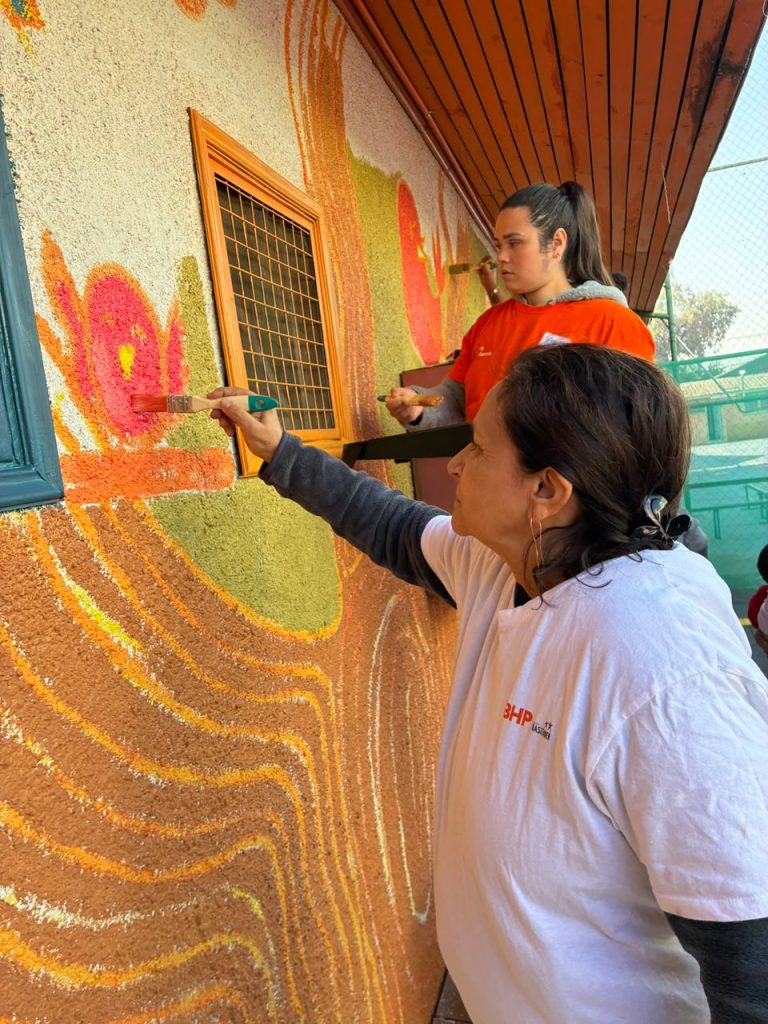 Voluntarios/as pintan muros para mejorar los espacios comunitarios para los niños.